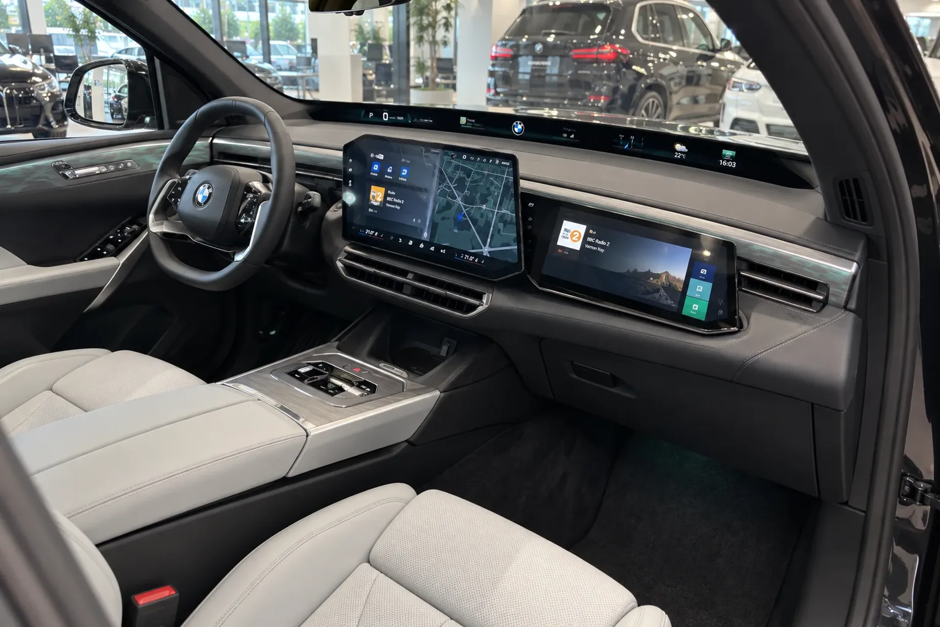 Светлый салон BMW X5 G65: вид через открытую пассажирскую дверь
